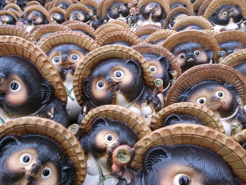Plusieurs dizaines de figurines de Tanukis, avec leur chapeau de paille